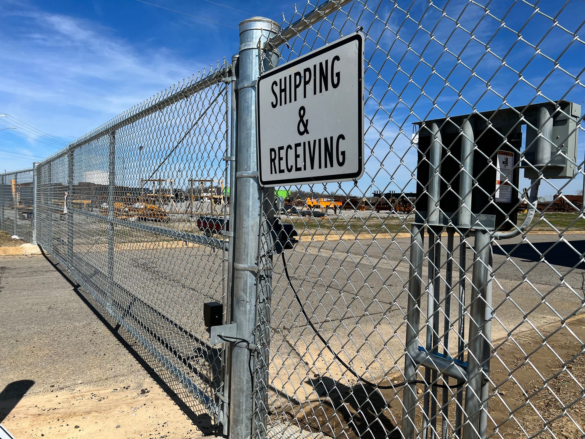 A chain link fence with a sign on it that says shipping and receiving.