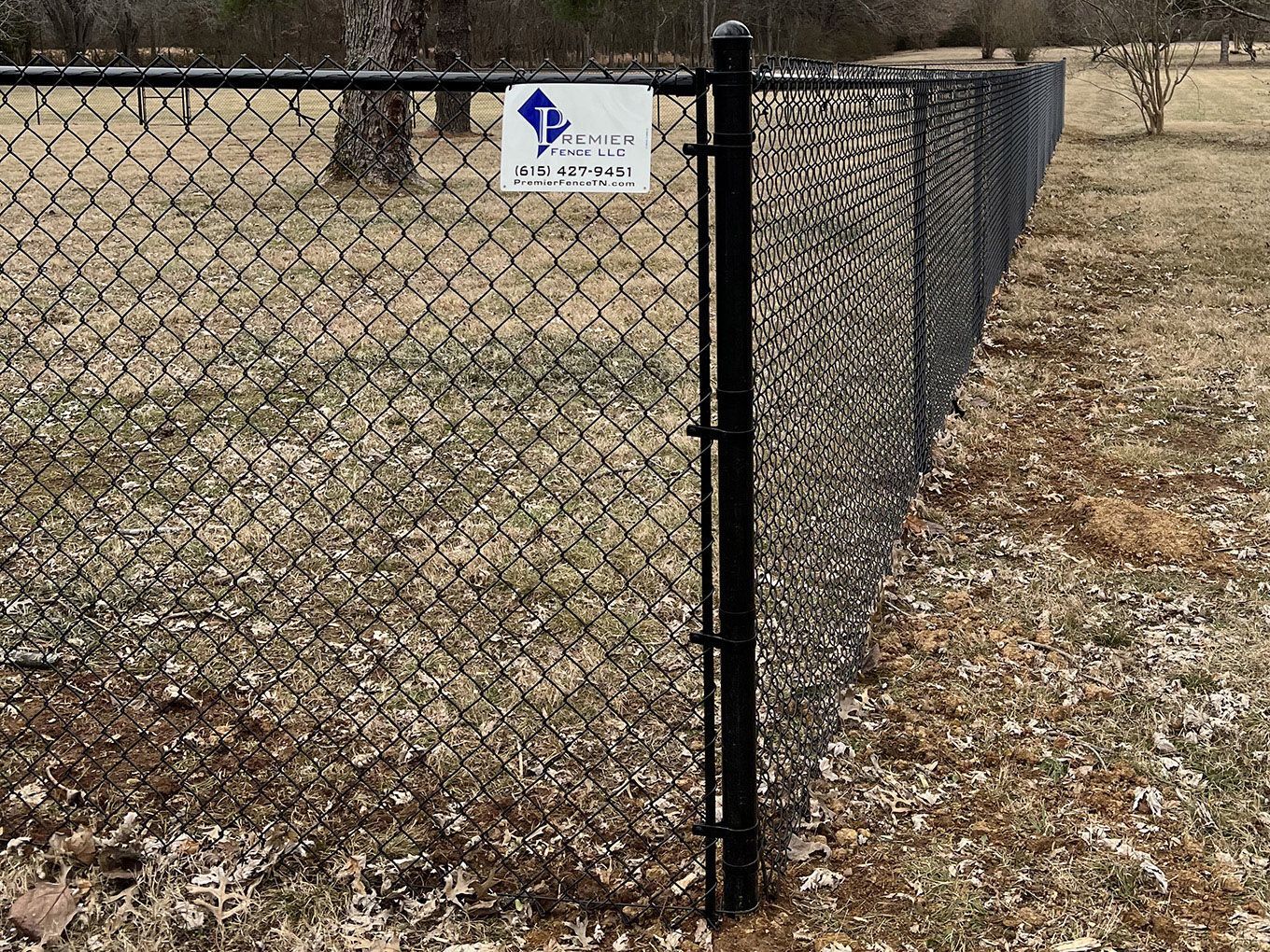 A chain link fence with a sign attached to it