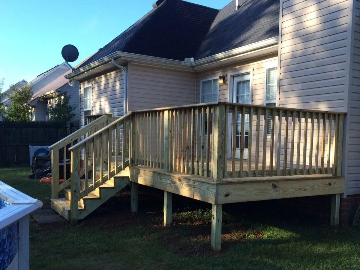 A wooden deck with stairs in front of a house