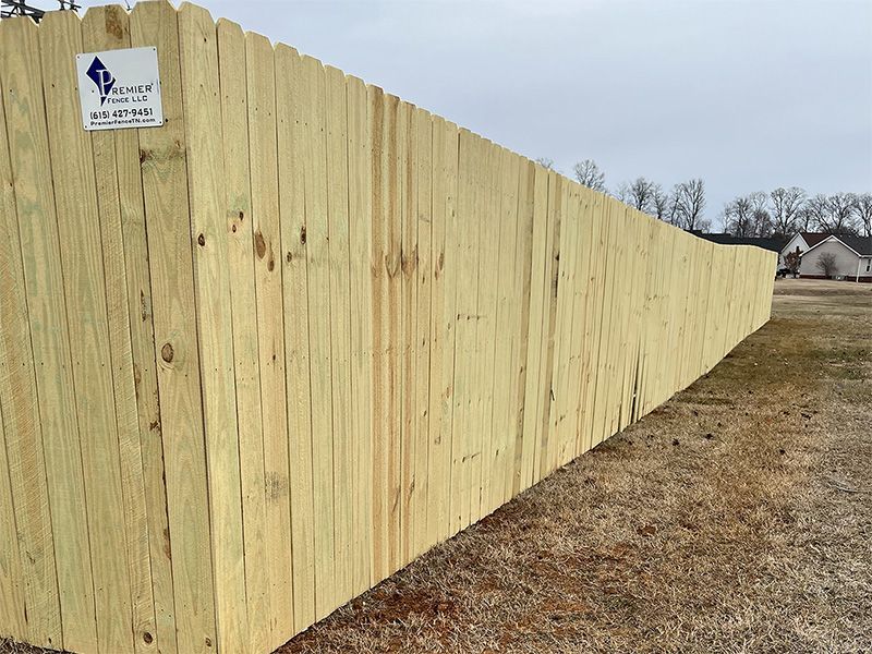 A long wooden fence with a sign on it