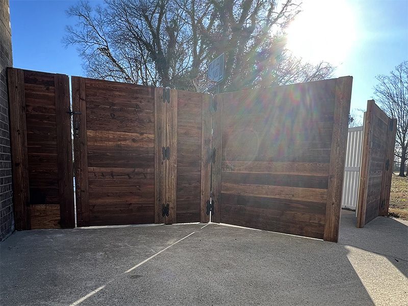 A wooden fence is sitting in the middle of a parking lot.