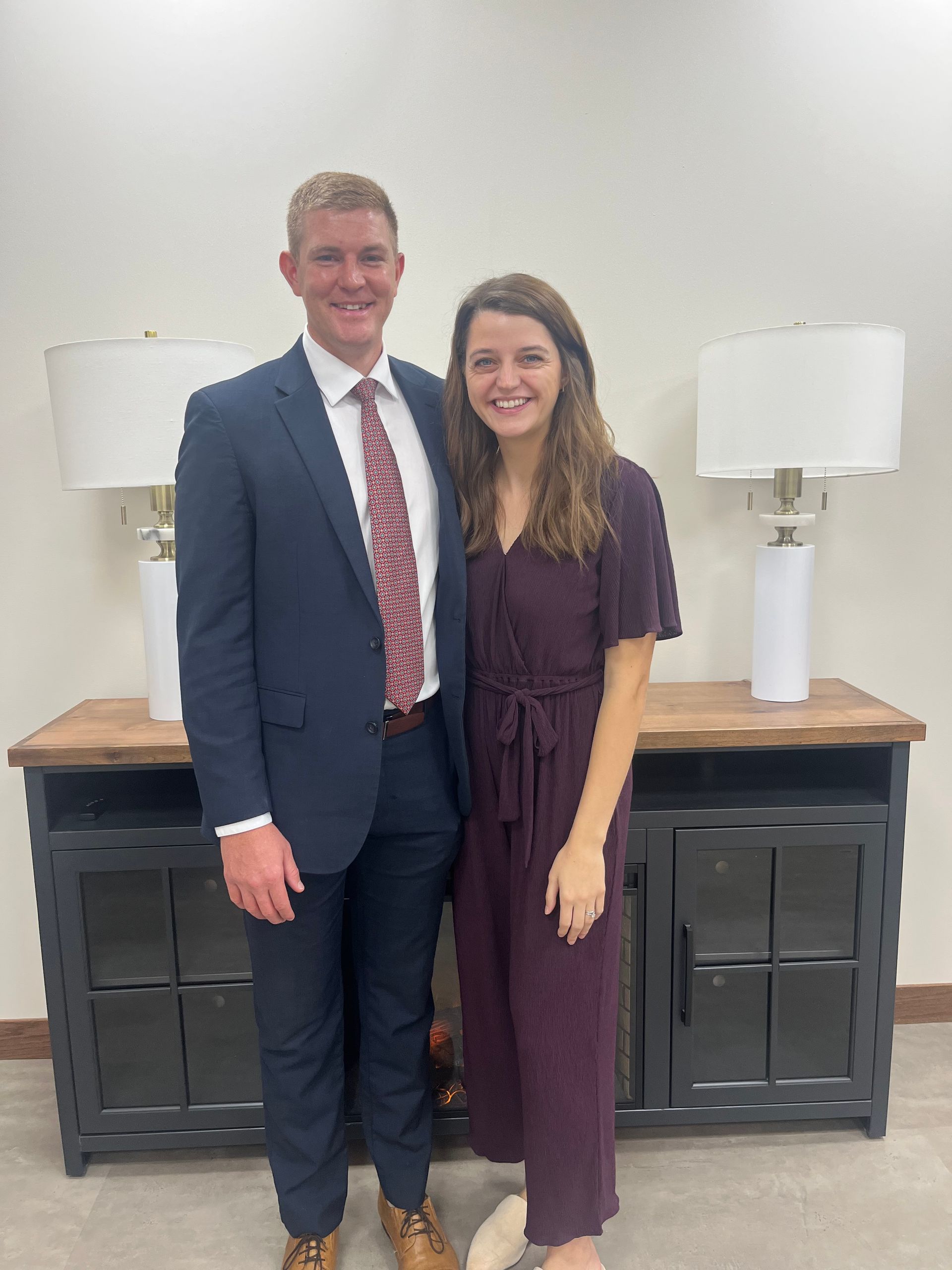 a large house is sitting on the shore of a lake surrounded by trees .