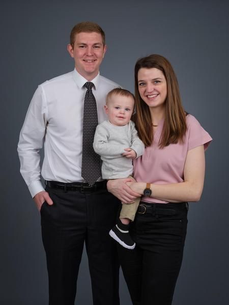a large house is sitting on the shore of a lake surrounded by trees .