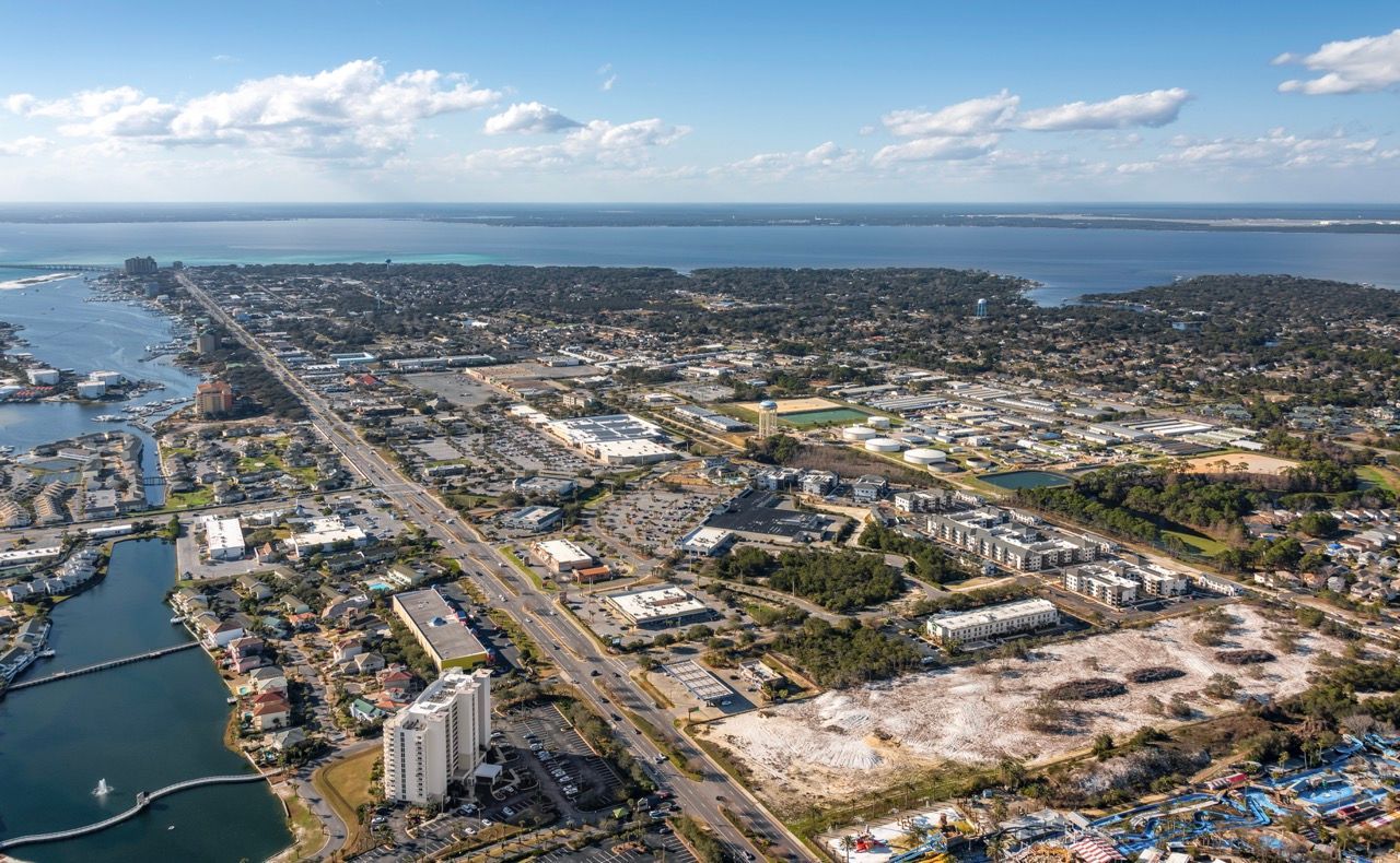 Aerial view of a coastal city with waterways and dense buildings.