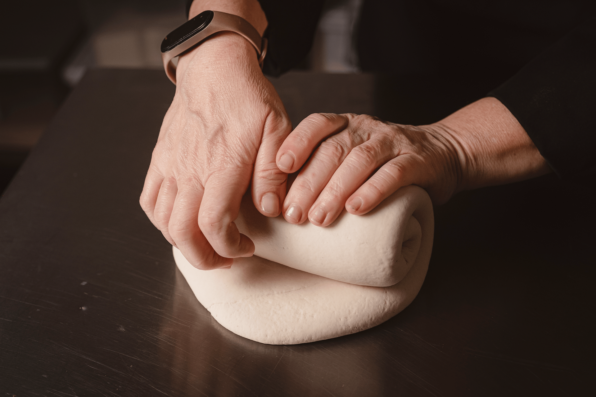 Una persona sta impastando un impasto su un tavolo.