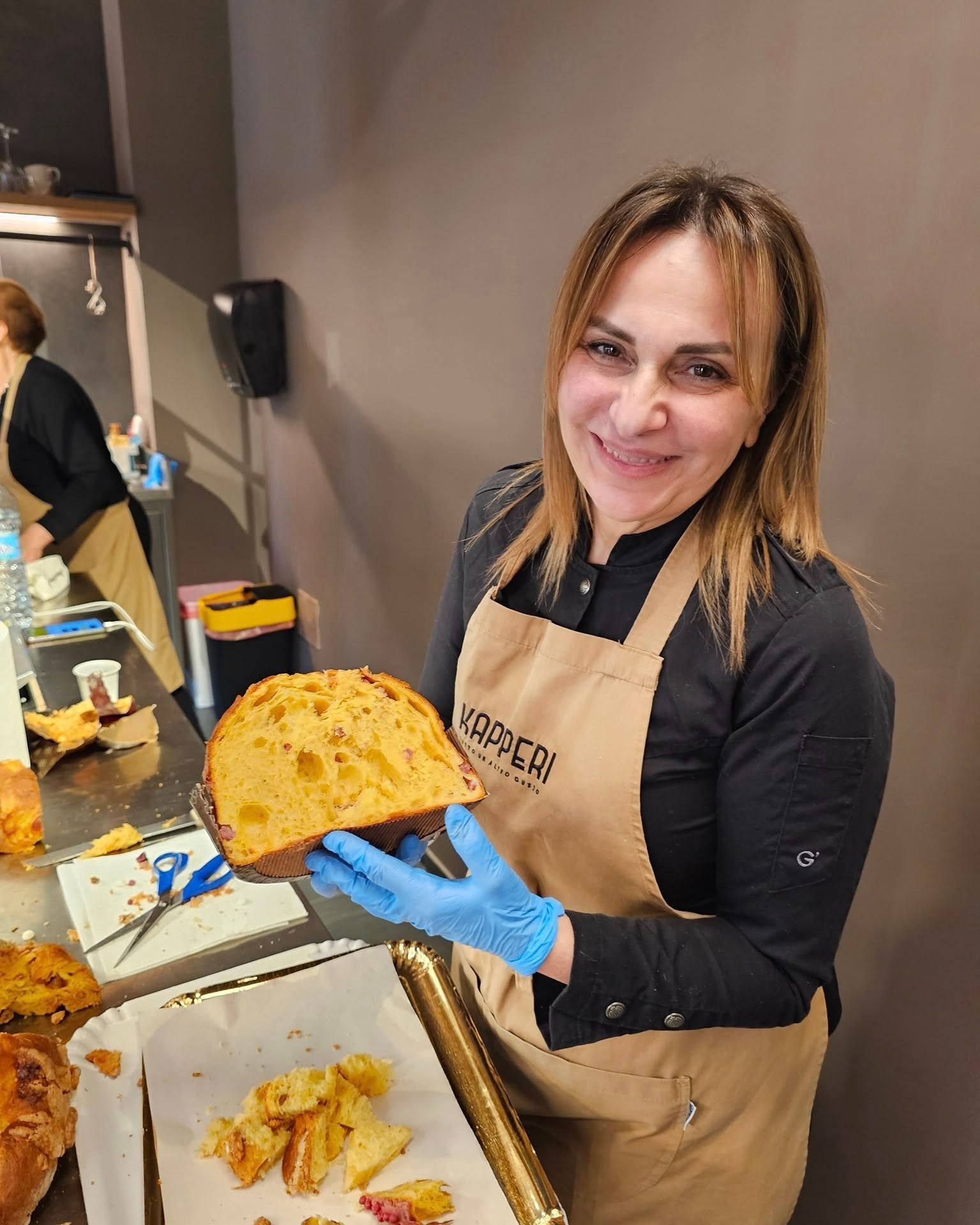 Una donna con una giacca nera tiene un ricciolo tra le mani.