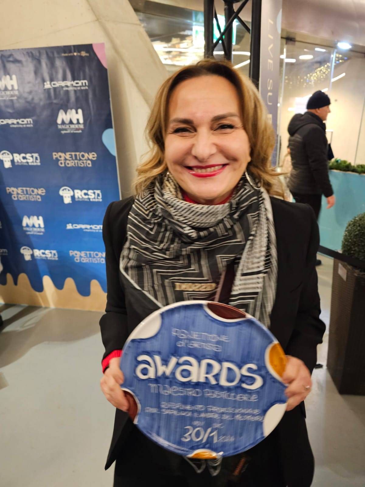 Una donna tiene in mano un piatto con la scritta