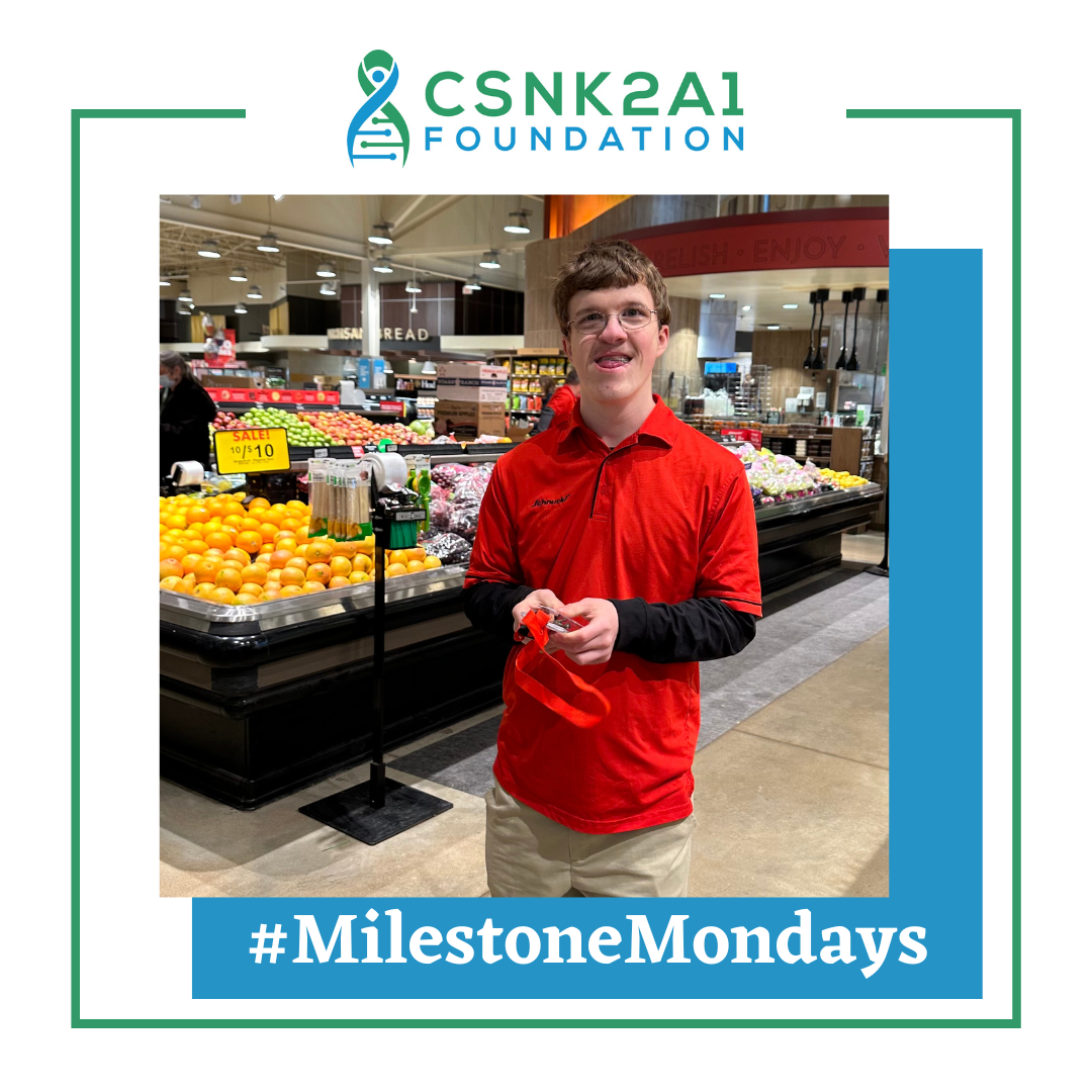 A young man in a red shirt is standing in a grocery store.