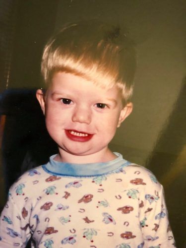 A young boy wearing pajamas is smiling for the camera.