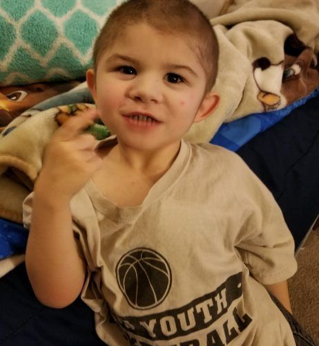 A young boy wearing a youth basketball shirt