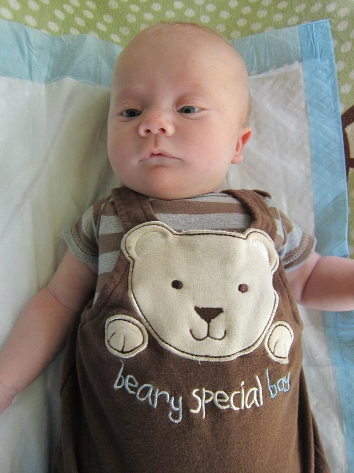 A baby is wearing a teddy bear outfit that says beary special bear.