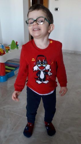 A young boy wearing glasses and a red shirt with a cat on it