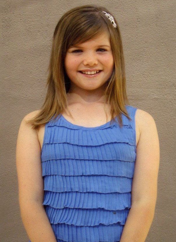 A young girl wearing a blue dress.