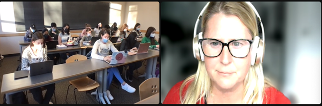 A woman wearing headphones is talking to a group of students in a classroom.