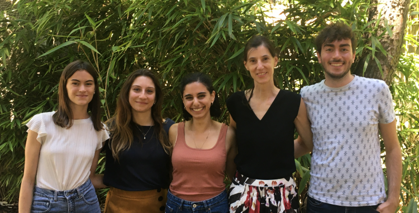 A group of people are posing for a picture in front of a tree.