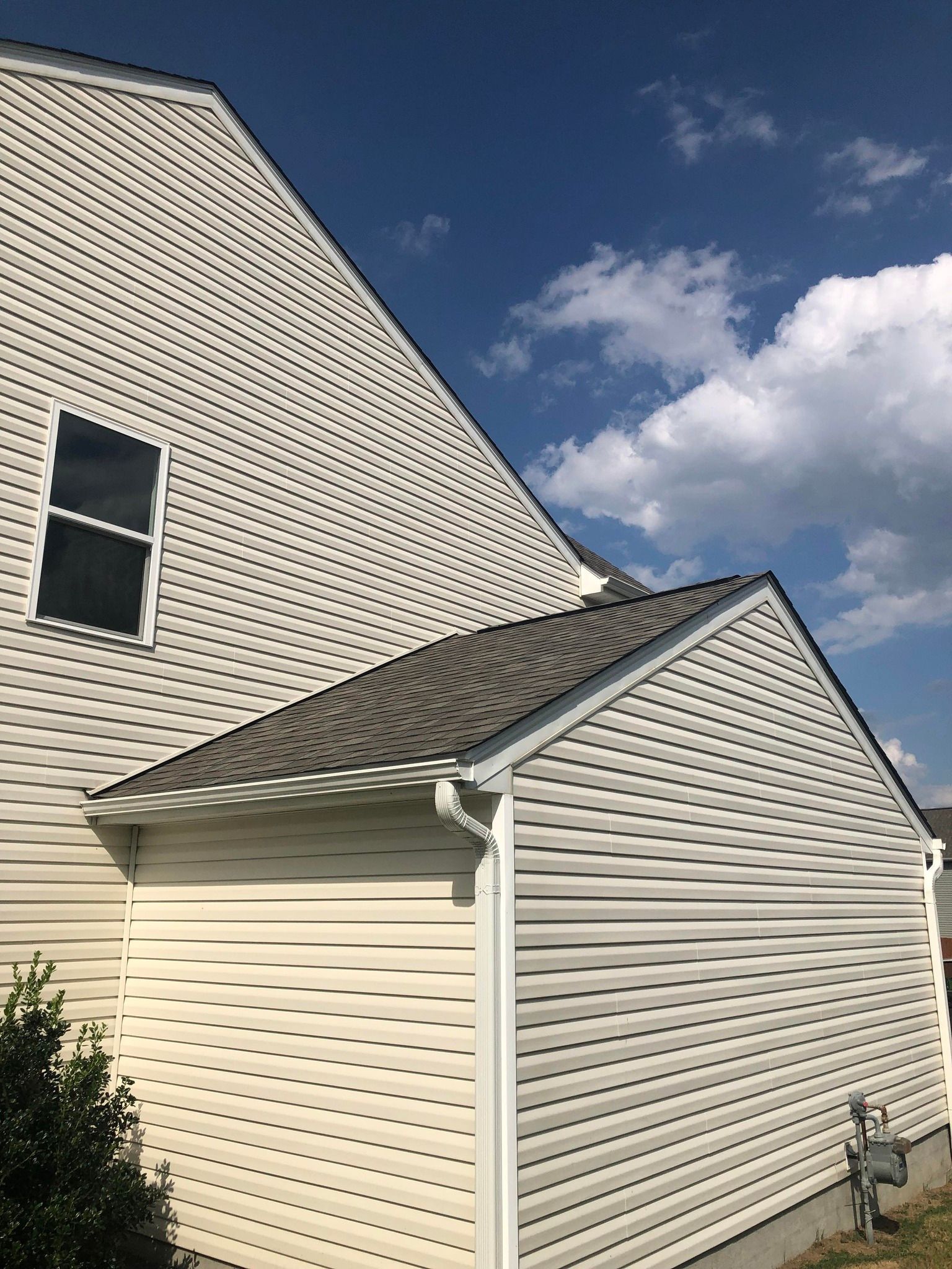 A white house with a garage and a blue sky in the background.