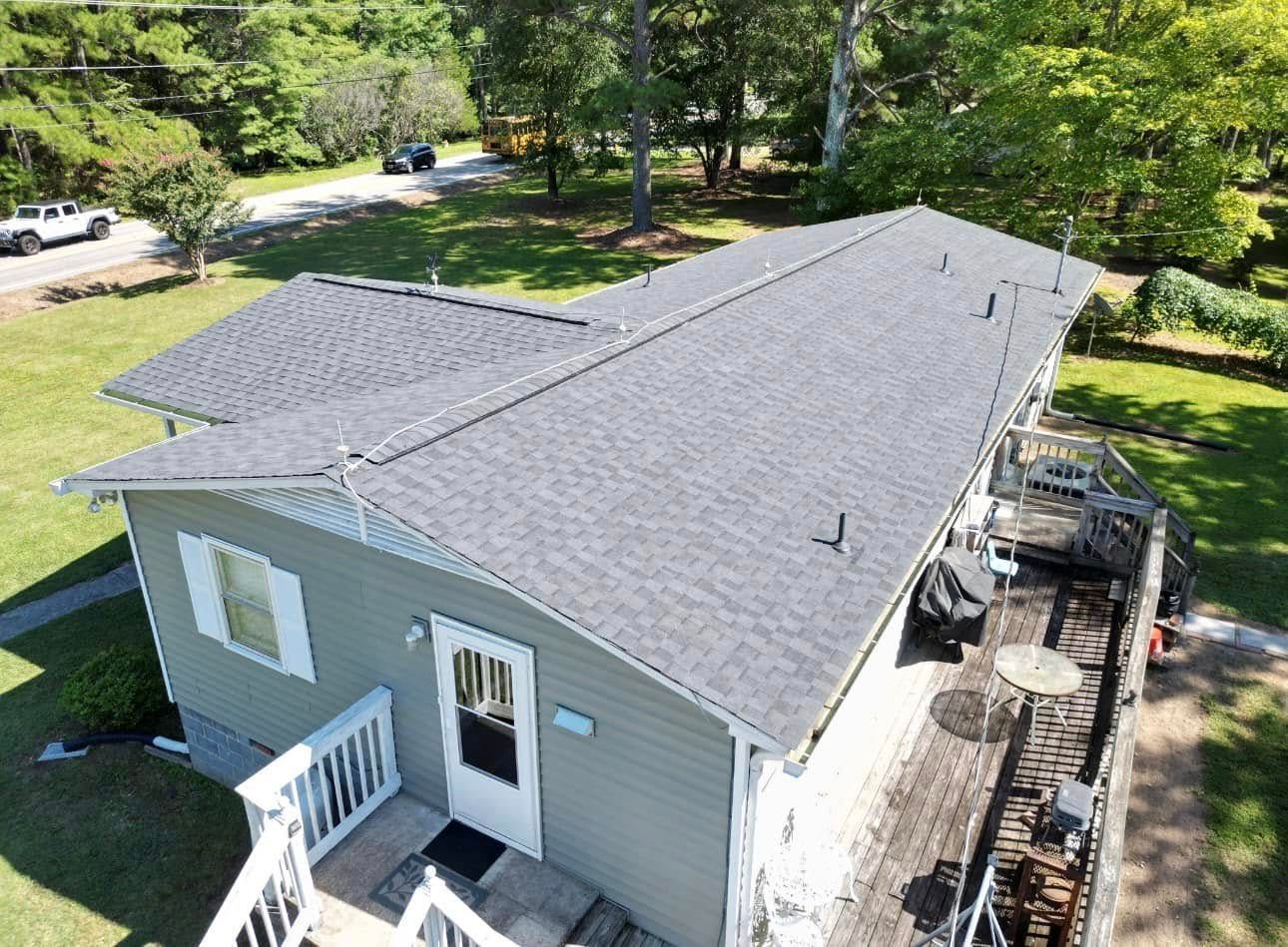 An aerial view of a small house with a new roof.