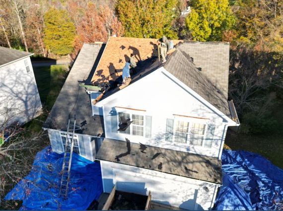 An aerial view of a house with a roof being repaired.