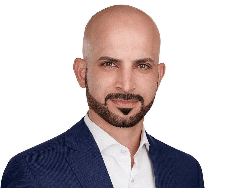 A bald man with a beard is wearing a blue suit and white shirt.