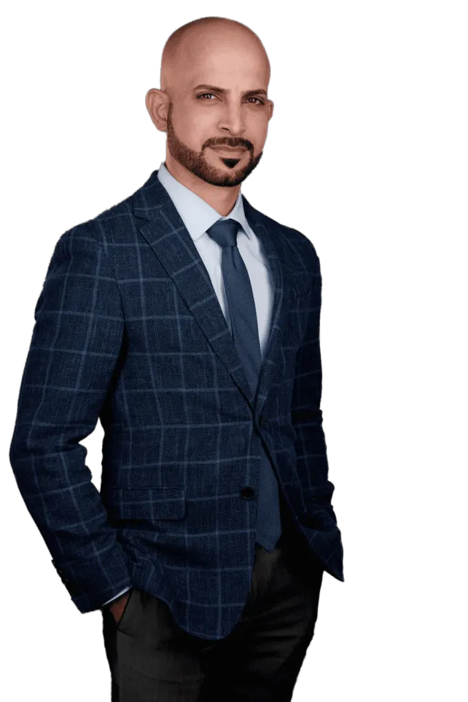 A man in a suit and tie is standing with his hands in his pockets.