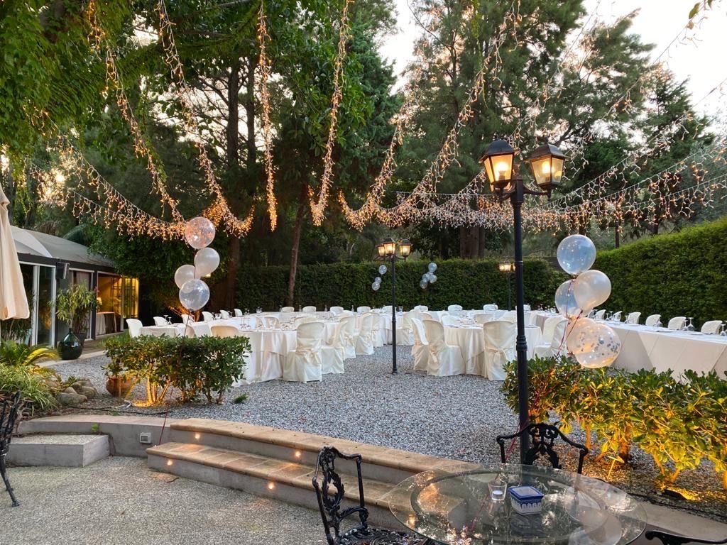 Un patio con tavoli e sedie allestito per un ricevimento di nozze.