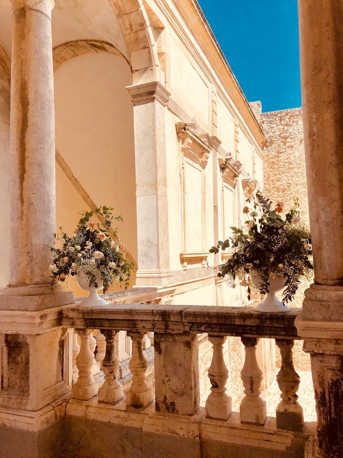 Un balcone con due vasi di fiori sopra