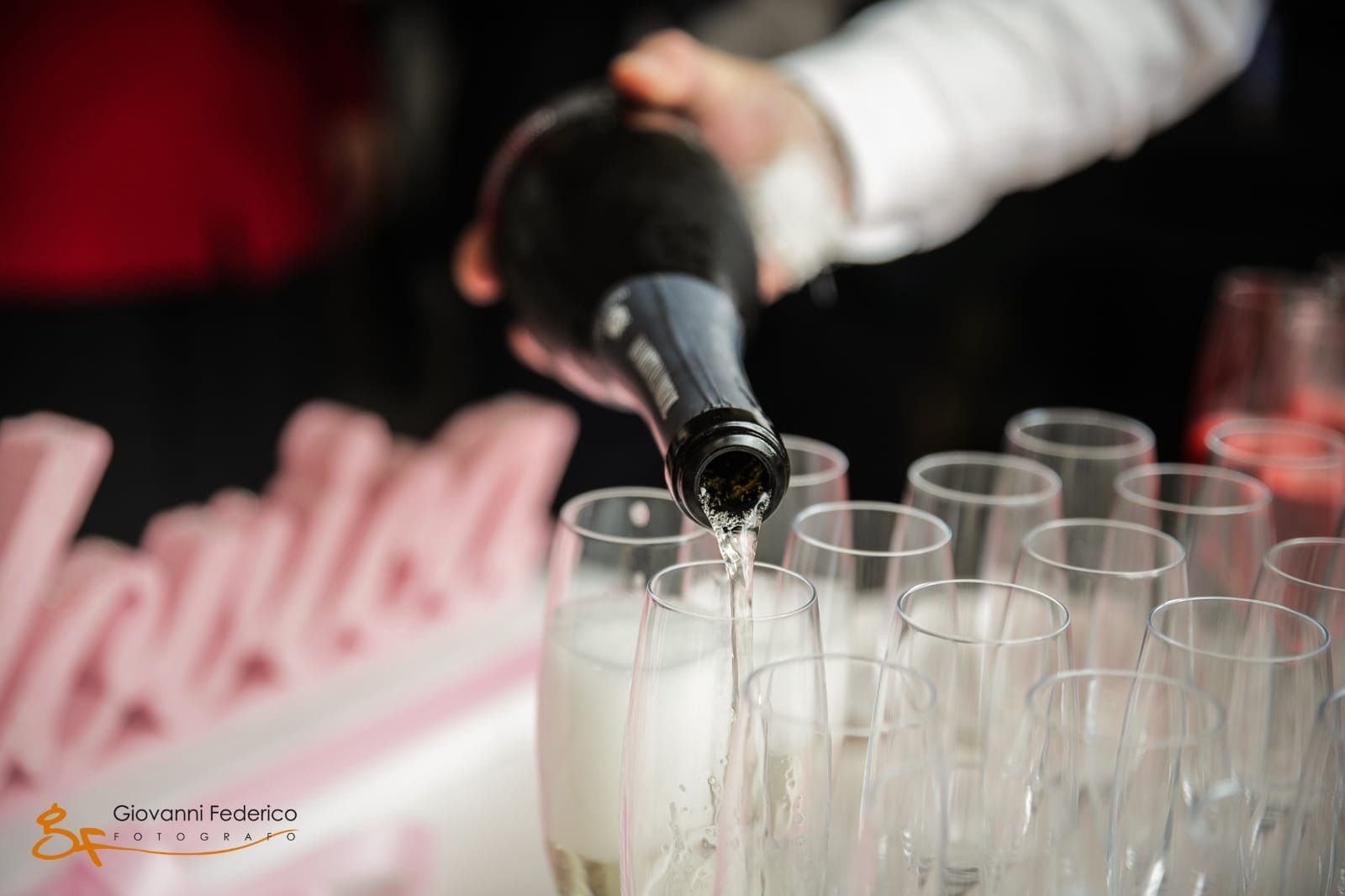 Una persona sta versando champagne nei bicchieri su un tavolo.