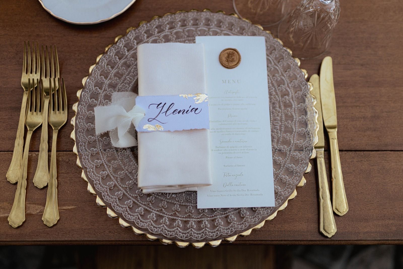 Una apparecchiatura con un menù, forchette e coltelli su un tavolo di legno.