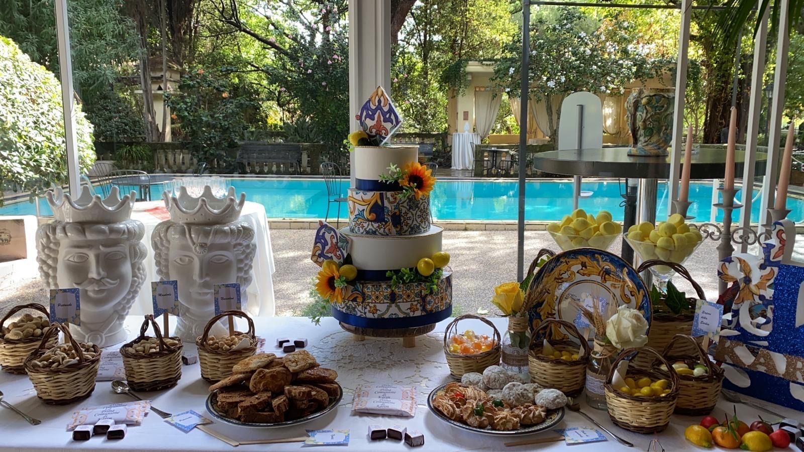 Un tavolo con una torta e un sacco di cibo sopra.