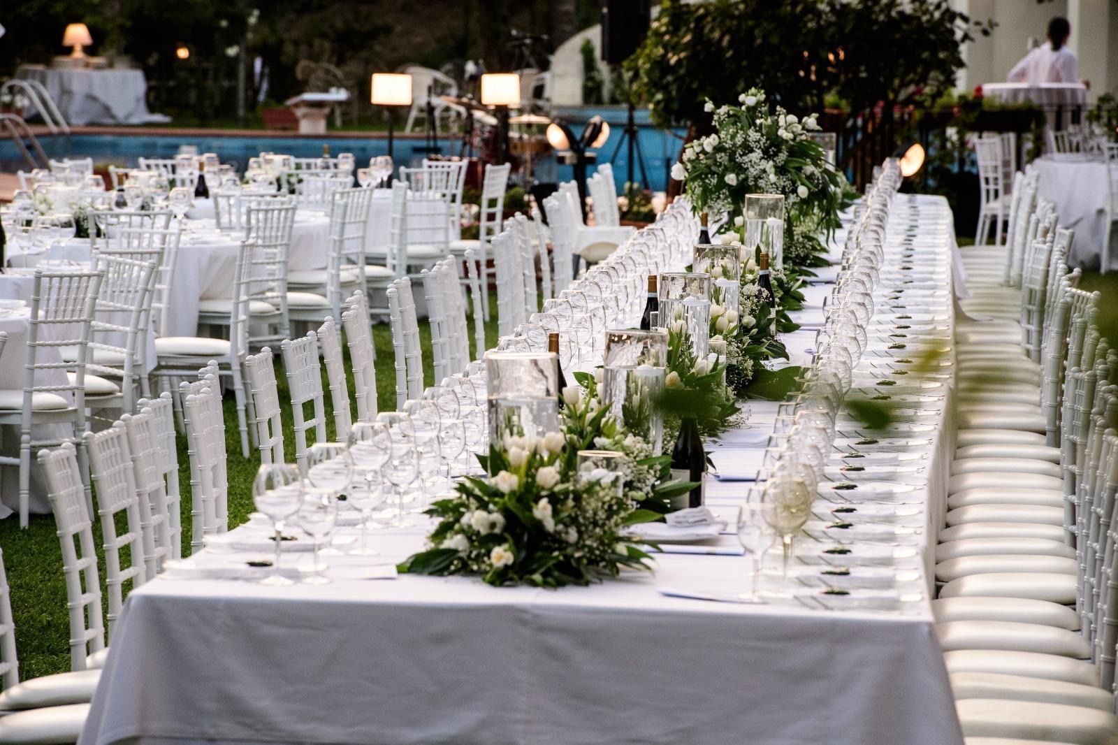 Un lungo tavolo con fiori e bicchieri di vino sopra