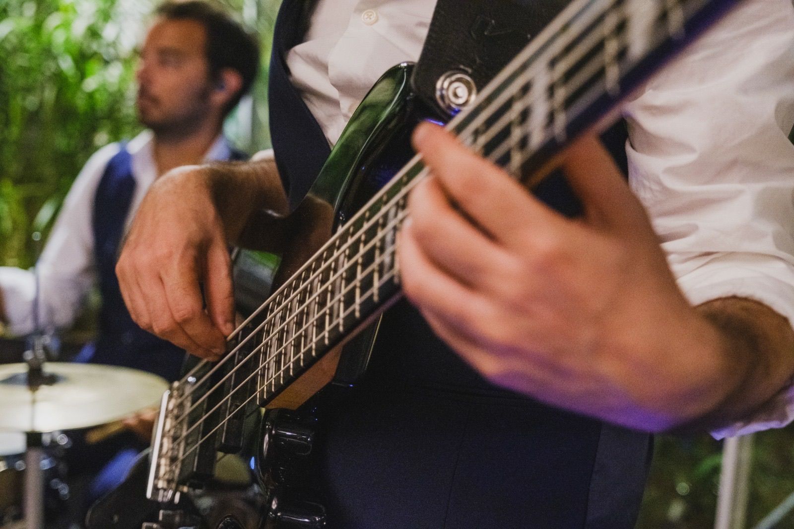 Un uomo sta suonando la chitarra davanti a una batteria.