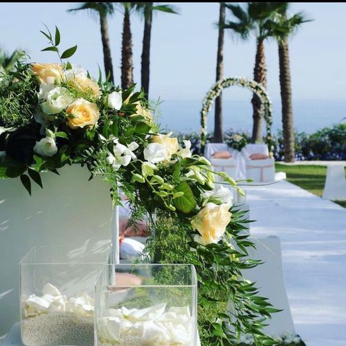 Una navata nuziale decorata con fiori e petali con palme sullo sfondo