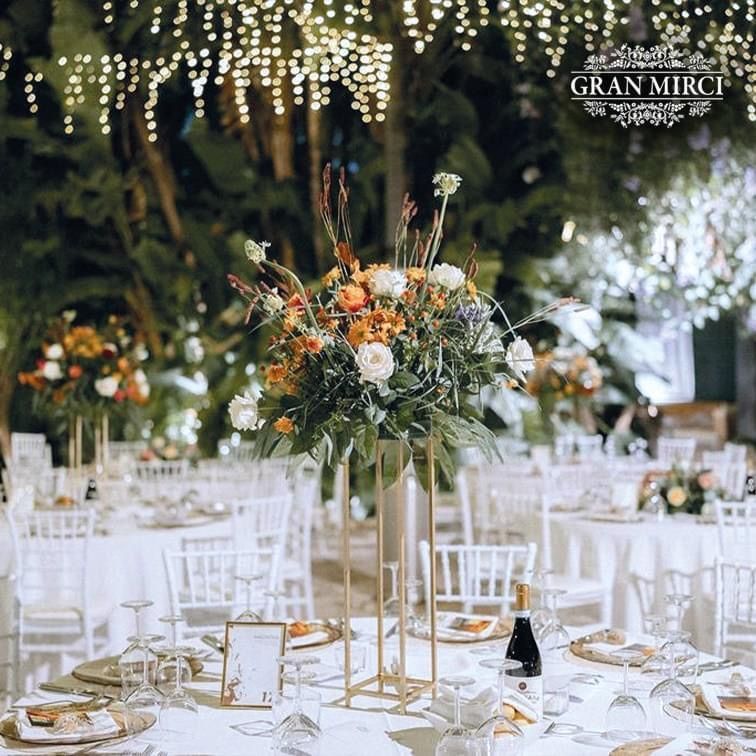 Durante un ricevimento di nozze, sul tavolo c'è un grande vaso di fiori.