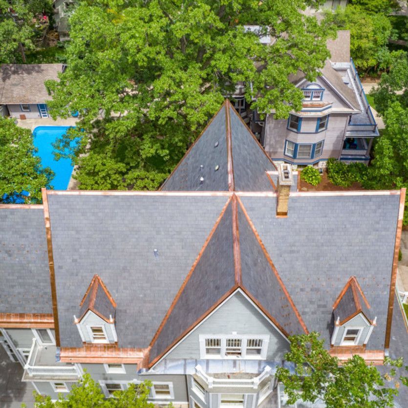 An aerial view of a large house with a copper roof
