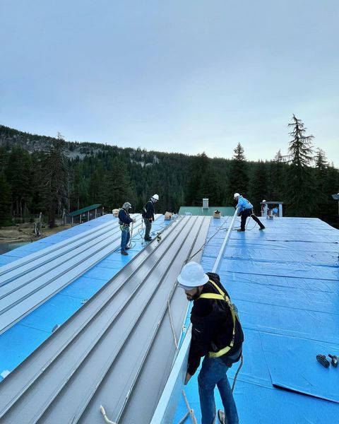 A group of men are working on the roof of a building