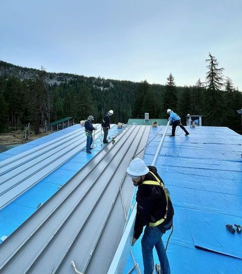 A group of men are working on the roof of a building