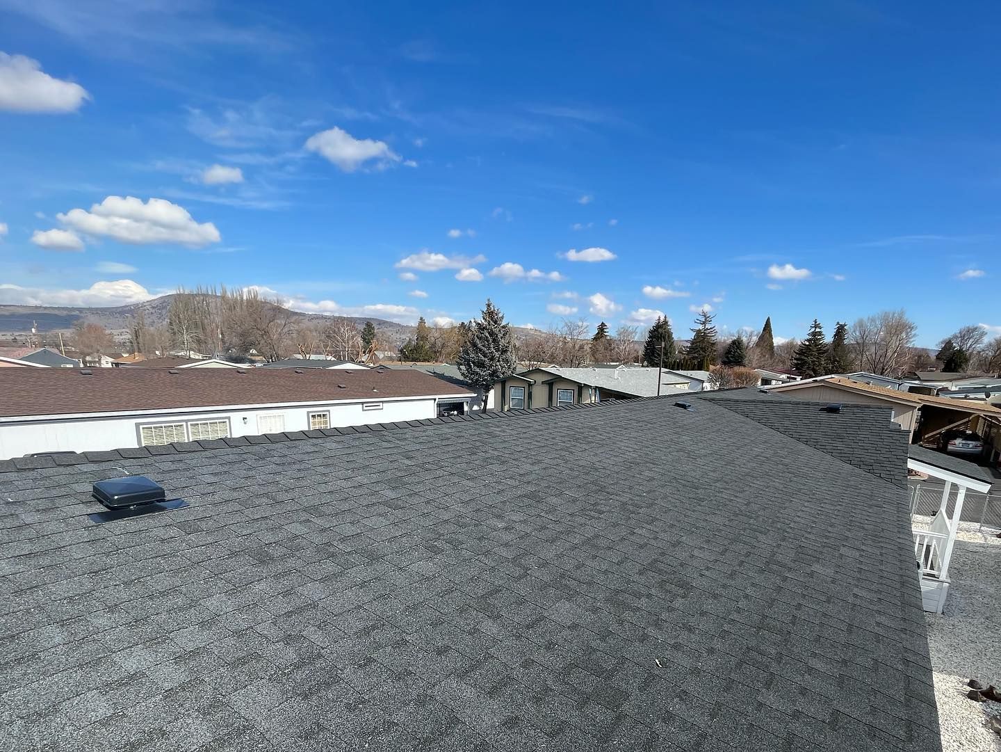 A roof with a lot of gravel on it and a blue sky in the background.