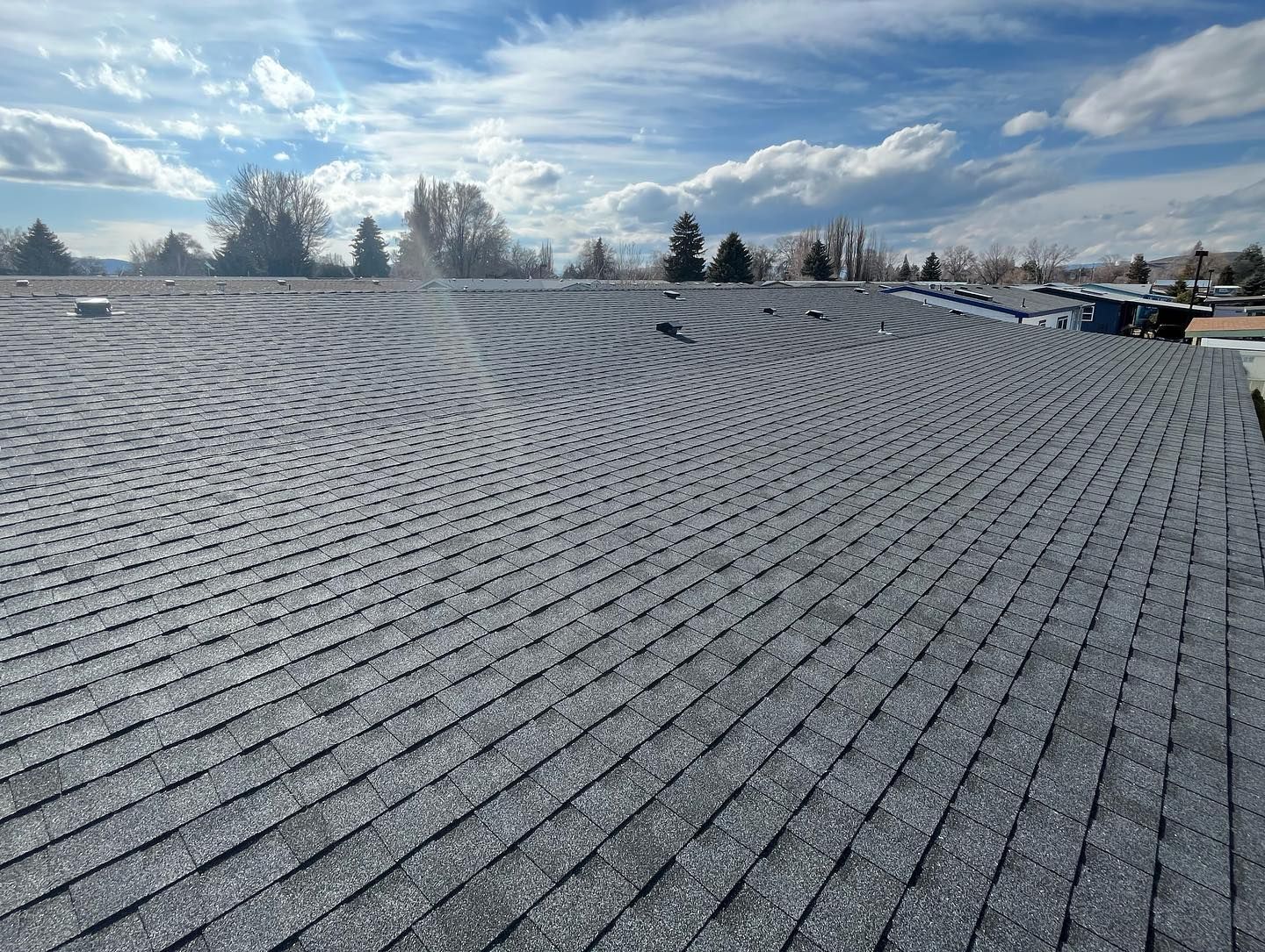 A roof with a lot of shingles on it and a blue sky in the background.