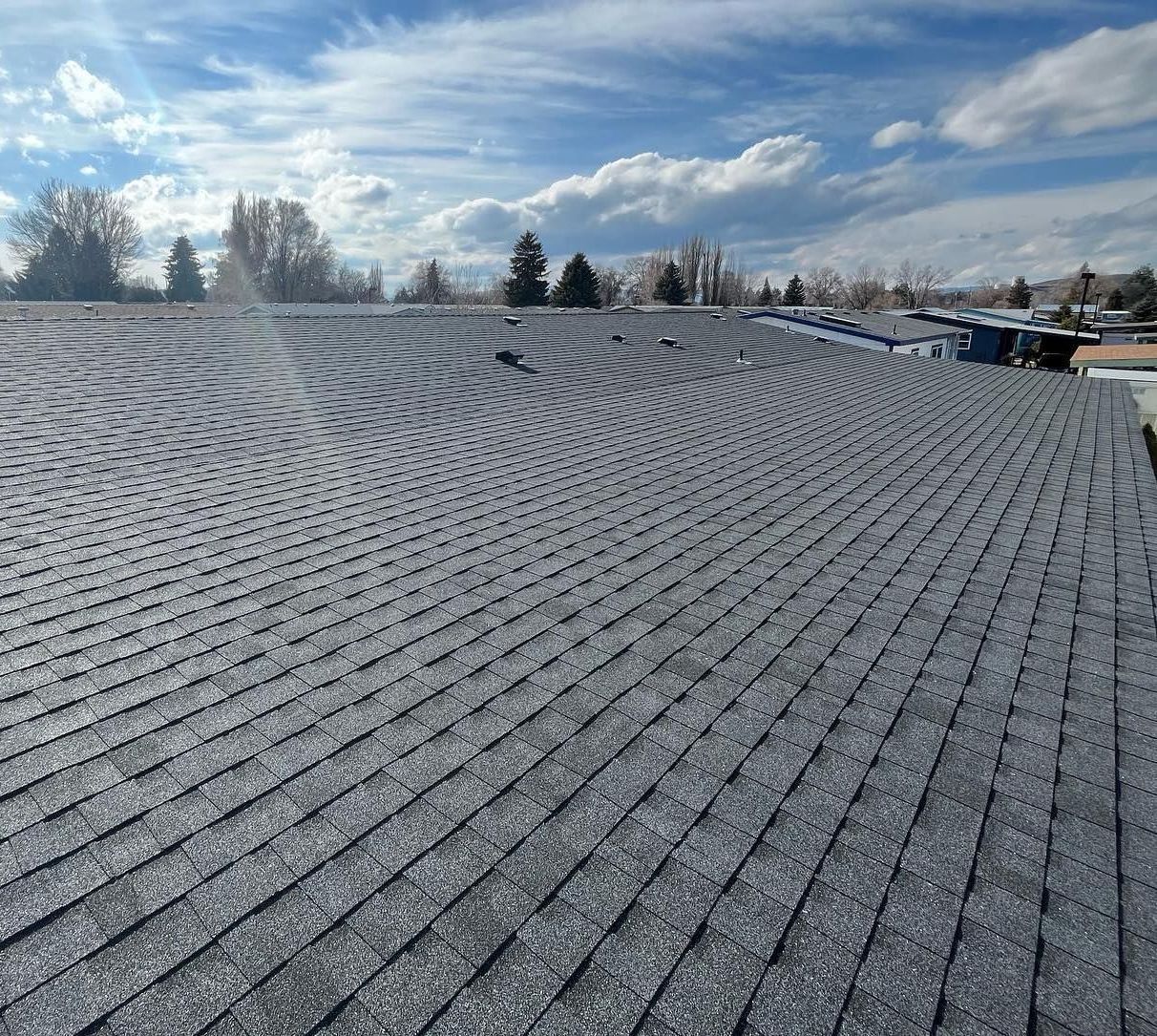 A roof with a lot of shingles on it and a blue sky in the background.