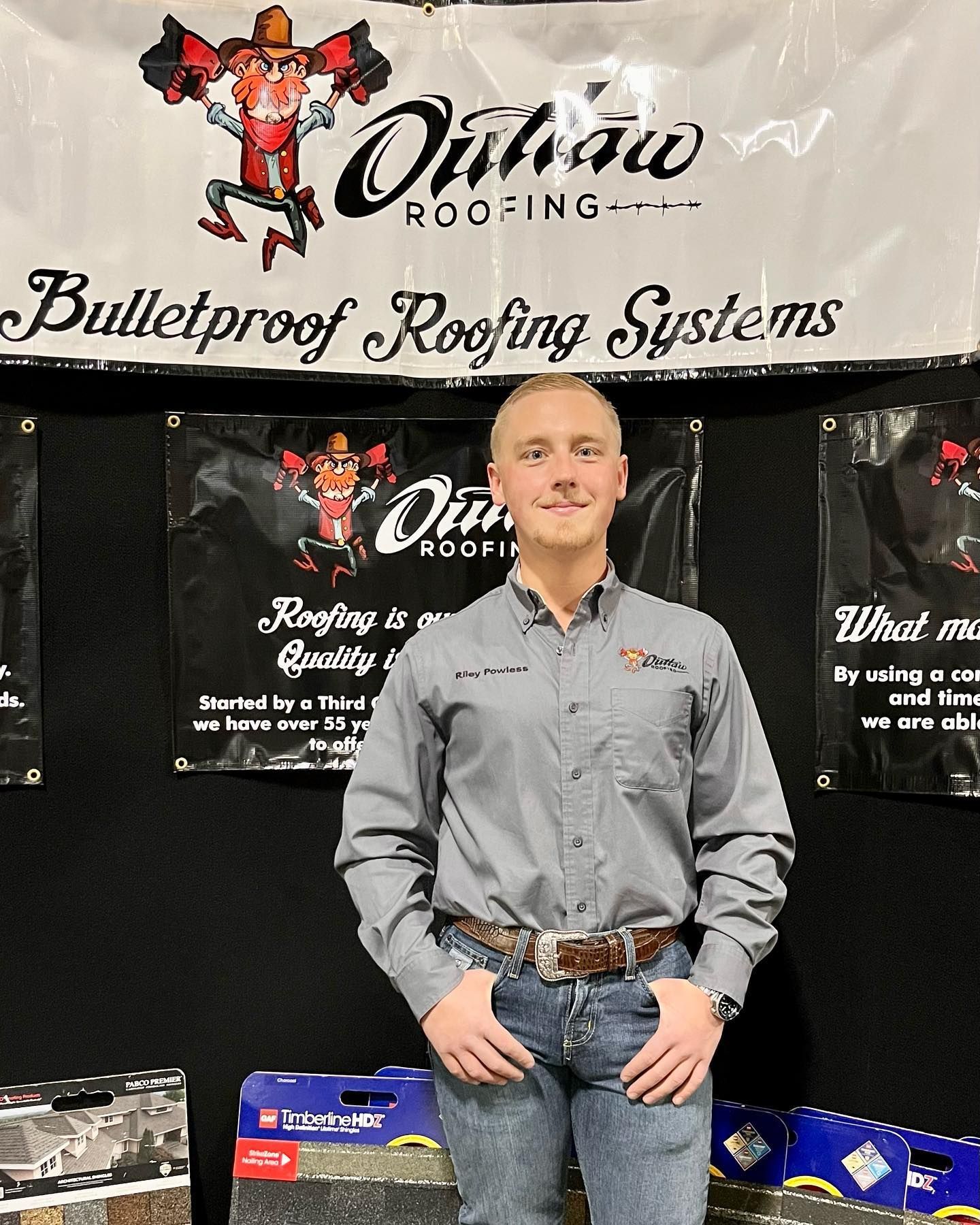 A man is standing in front of a sign that says bulletproof roofing systems
