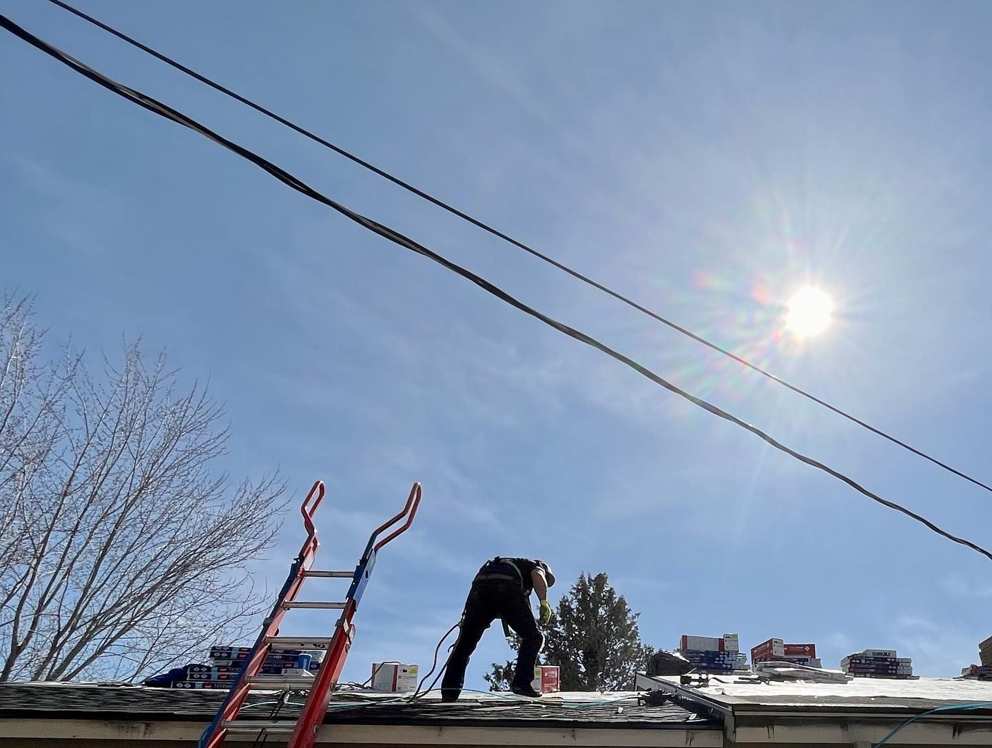 A man is working on the roof of a house with a ladder