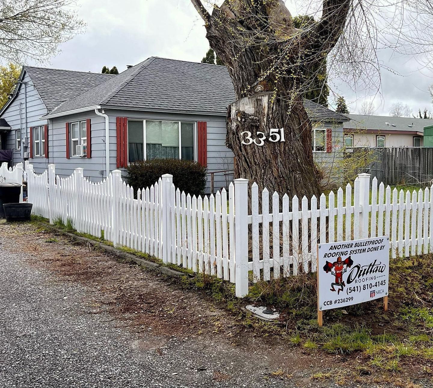 A house with a white picket fence and a sign in front of it