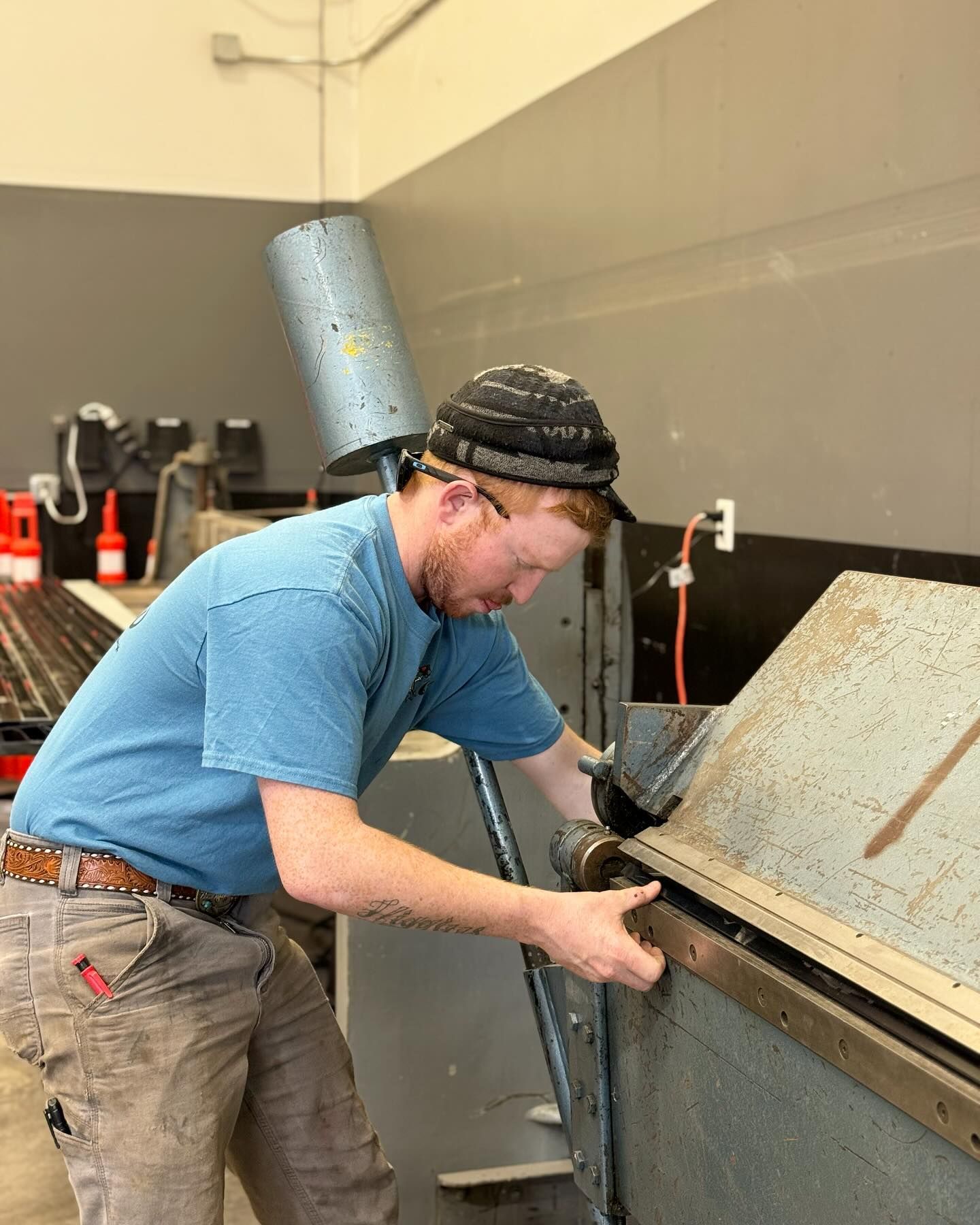 A man in a blue shirt is working on a machine