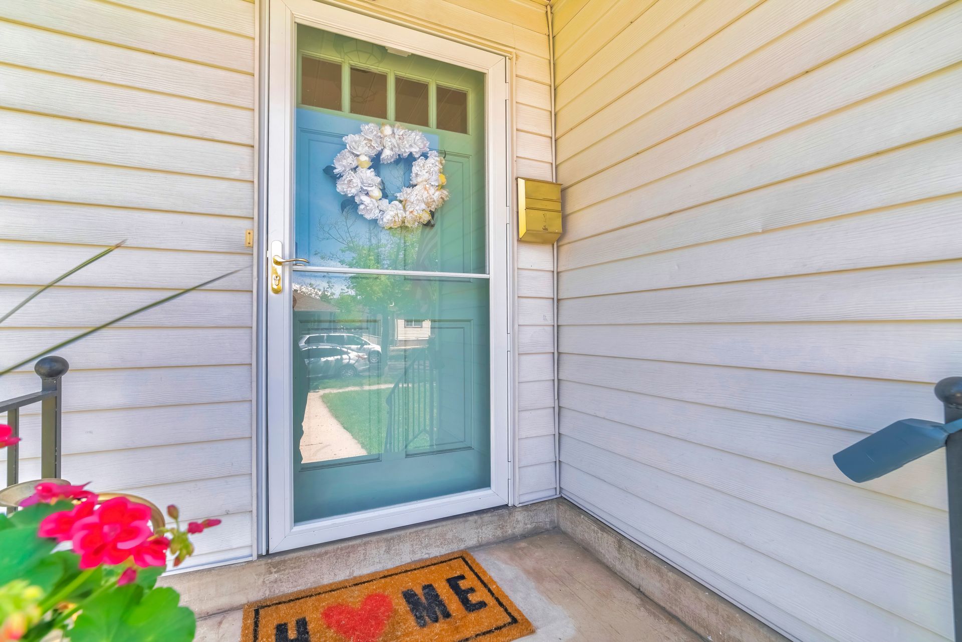 A door with a wreath on it and a door mat that says `` home ''.