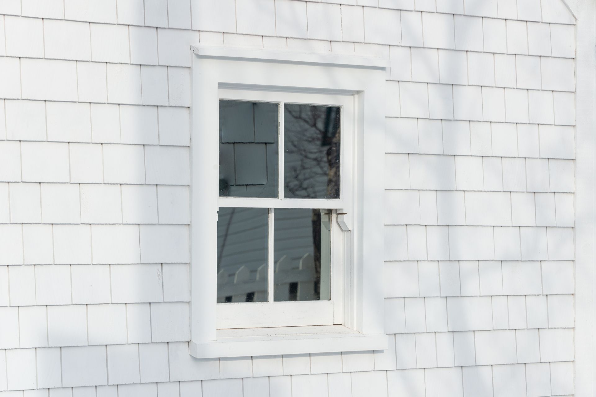 A white window on the side of a white house