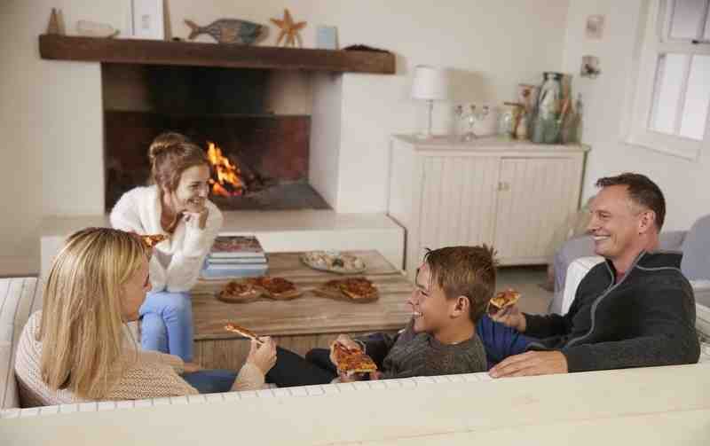 family comfortably gathered in a warm living room - furnace tune up specials