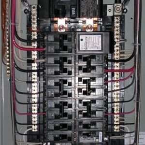 Electrical breaker panel with rows of black circuit breakers and red/black wiring inside a metal box