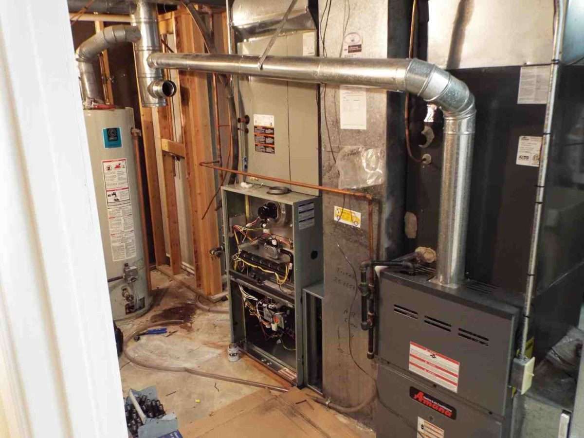 Basement utility room with furnace, ductwork, water heater, and exposed pipes along unfinished walls.