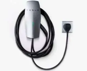 Tesla electric vehicle charging cable with wall connector, black cord coiled around white charger unit