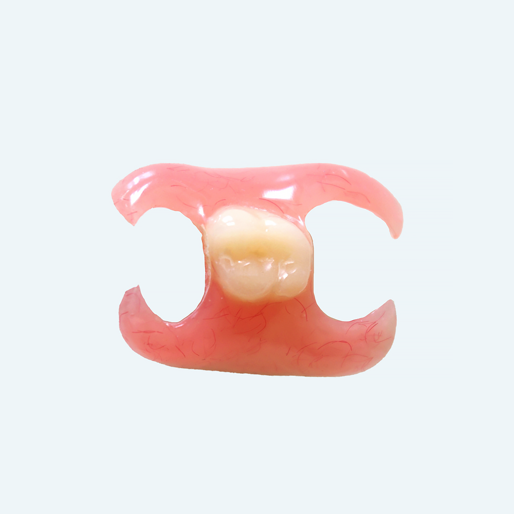 Partial denture with a single tooth, pink base, cream-colored tooth replacement, against a light blue background.